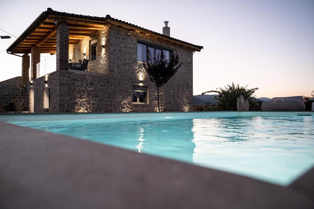 a villa with a swimming pool in front of a house at Villa Arancia in Argos