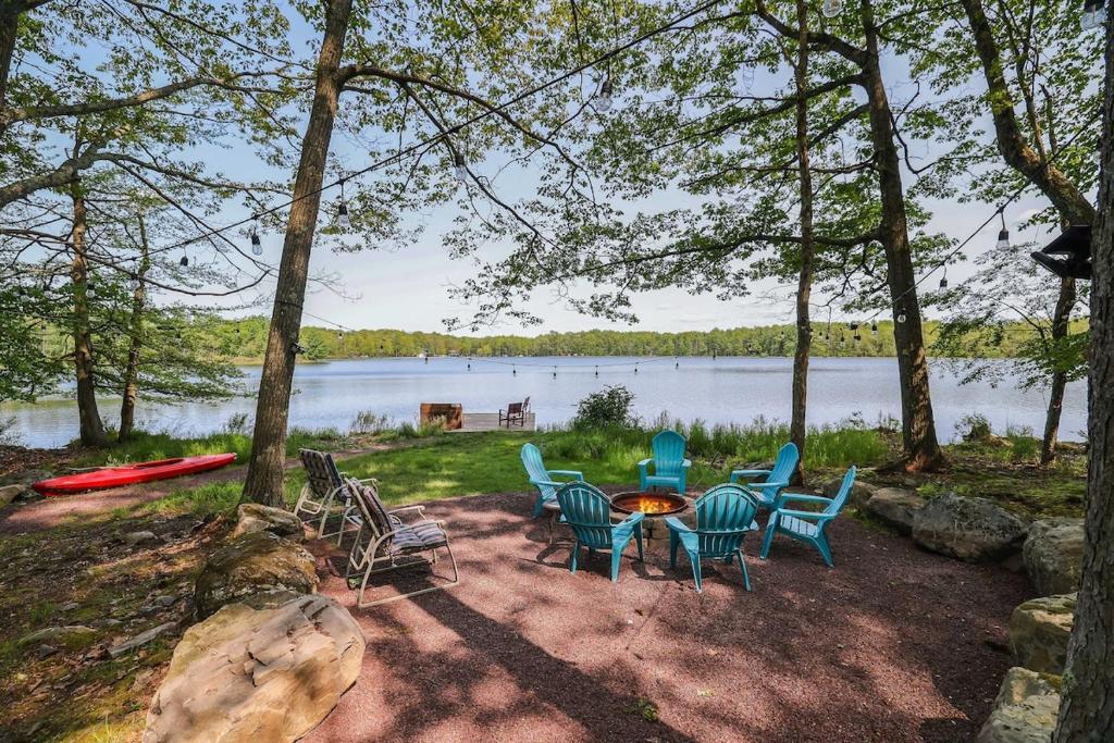 a group of chairs and a table next to a lake at Lake Front Firepit Dock Game Room Pets OK in Locust Lakes Village