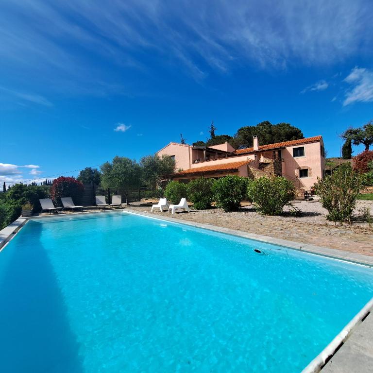 a swimming pool with a house in the background at Mas del Sola in Castelnou