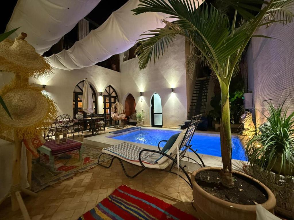 a living room with a pool and a palm tree at Villa Bouchra in Marrakesh