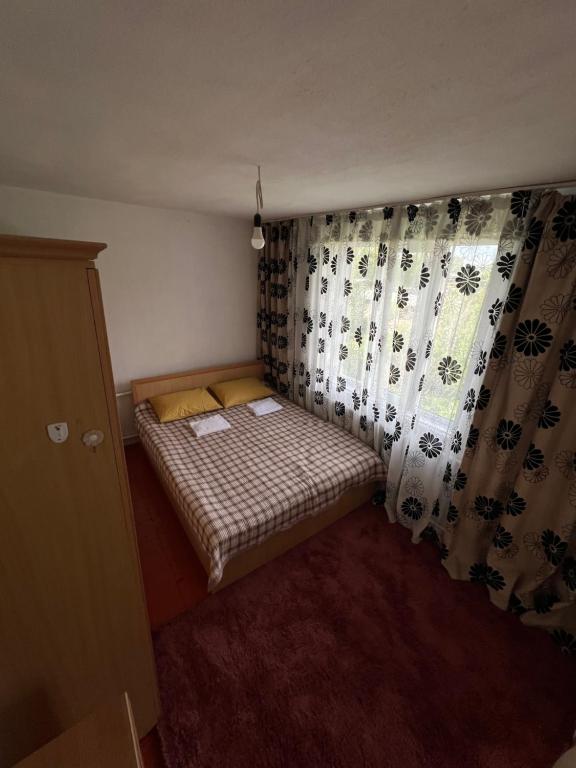 a small bed in a small room with curtains at Village stay in Kaindy
