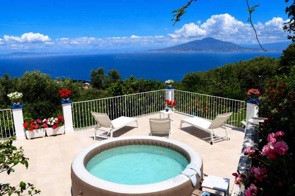 a hot tub on a patio with a view of the ocean at Blu Vesuvius Sorrento in Sorrento