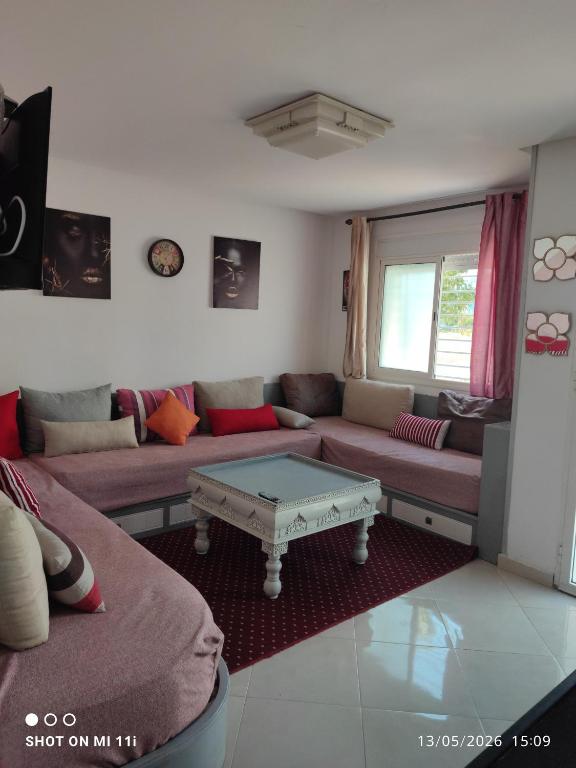 a living room with a couch and a coffee table at Isco Stam in Martil