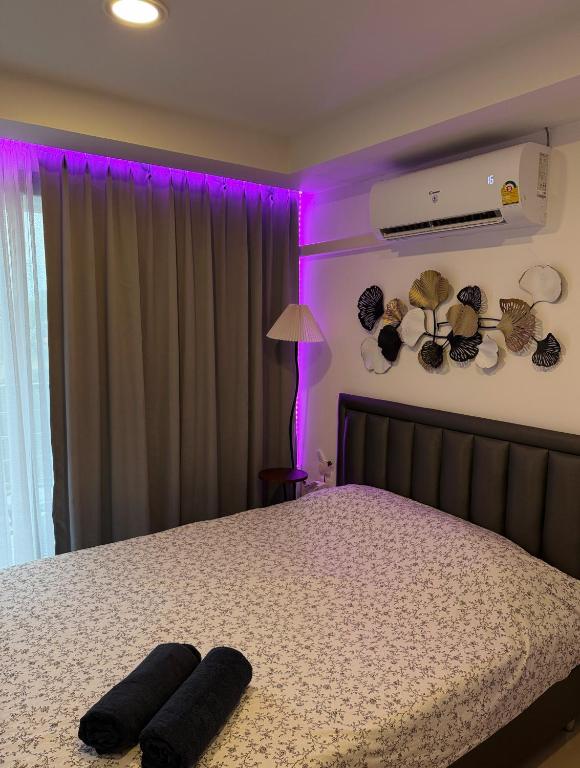 a bedroom with a bed with purple lights on it at Sunset view apartment with a pool MAIKHAO Phuket in Ban Mai Salae
