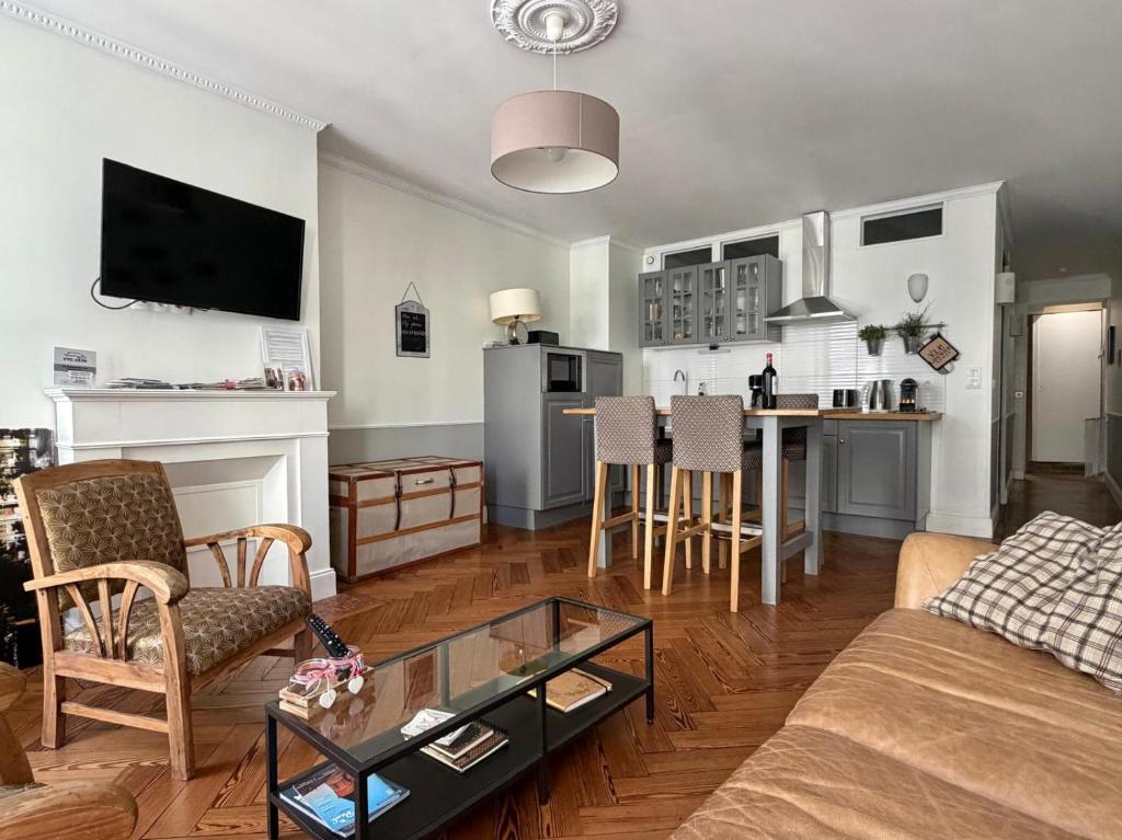 a living room with a couch and a table at L'Appart D'Oli et Tiane in Bordeaux