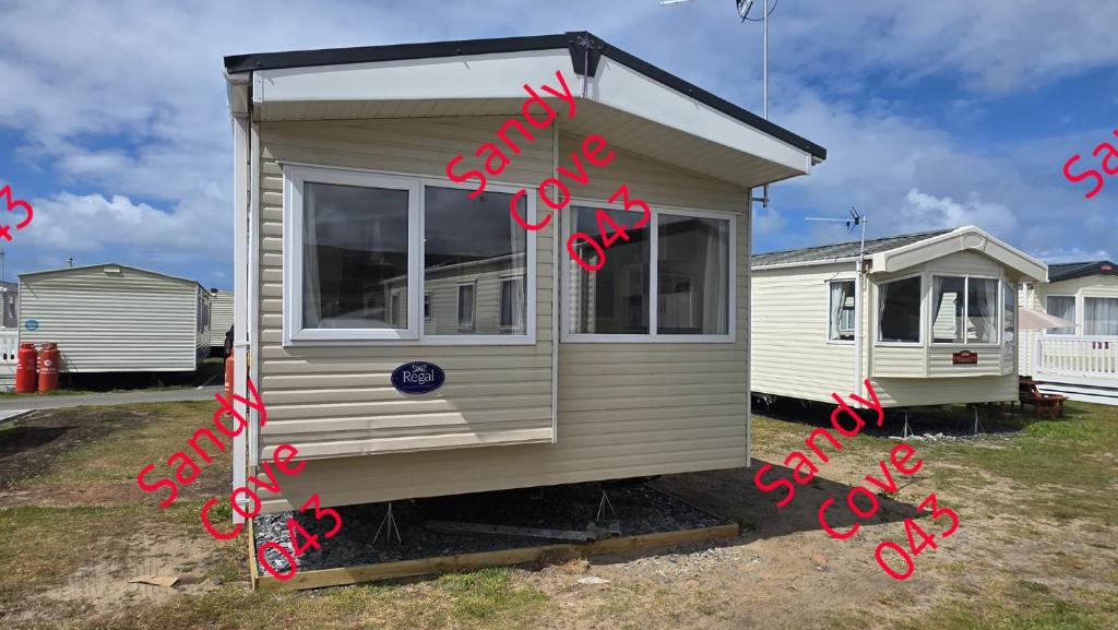 a tiny house with red writing on it at Sandy cove 043 in Barmouth