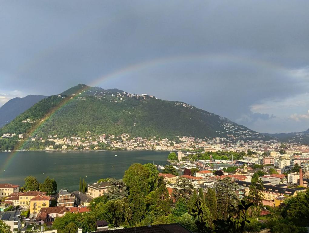 a view of a city and a mountain with a rainbow at Como Lake Chic Retreat - Lake View - Self Checkin in Como