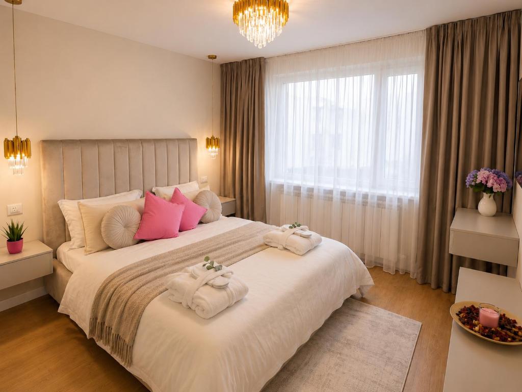 a bedroom with a large bed with towels on it at A&K Apartament in Bacău