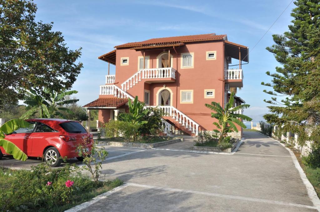a red car parked in front of a house at Neptune Resort in Kavos