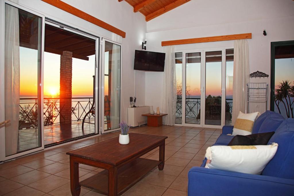 a living room with a blue couch and a table at Villa Panorama in Kalamitsi
