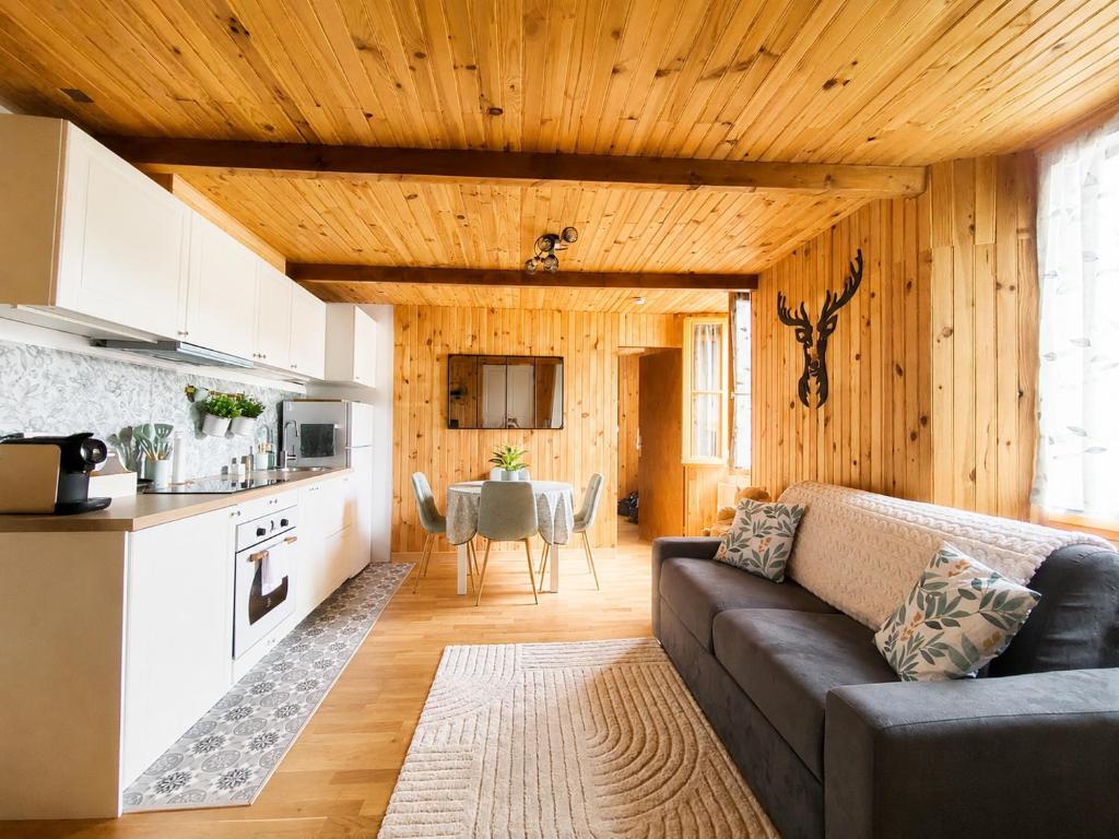 a living room with a couch and a kitchen at Le cocon beuillois in Beuil