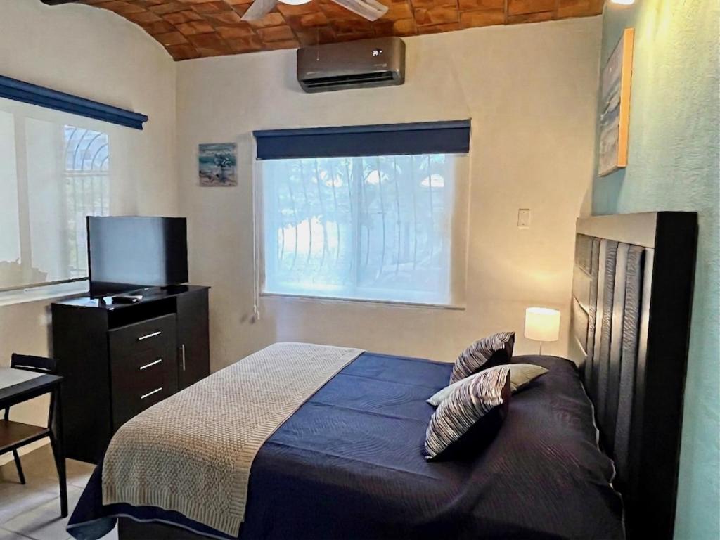 a bedroom with a bed and a dresser and a window at "Le Petit Oasis" Pool, AC and Beach 1 minute away in La Peñita de Jaltemba