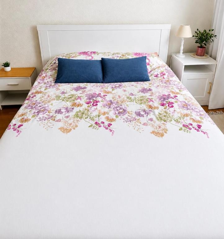 a bedroom with a bed with a floral bedspread at Fribourg Home in Fribourg