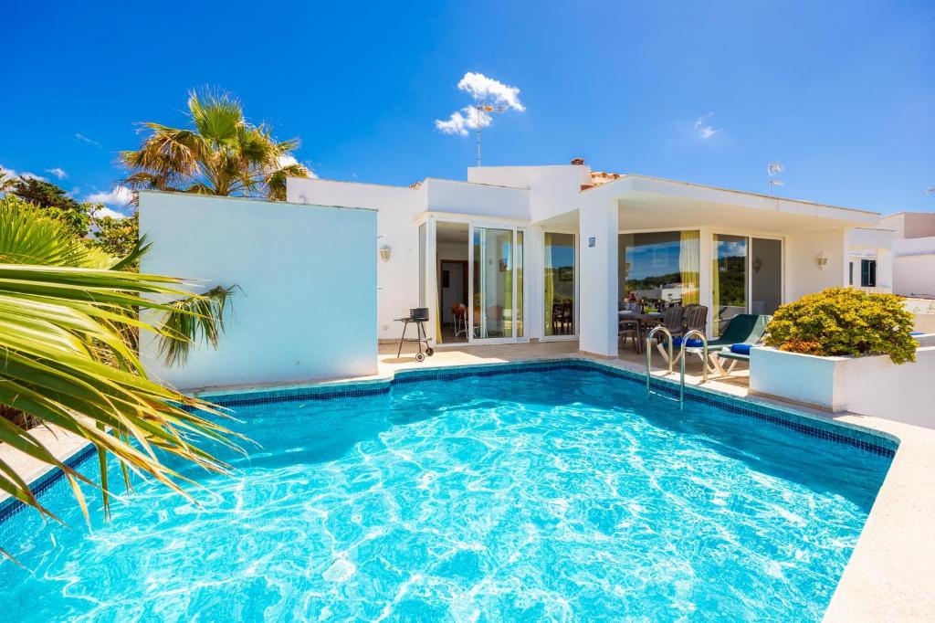 a villa with a swimming pool in front of a house at Villa Elena Dorada in Port d'Addaia