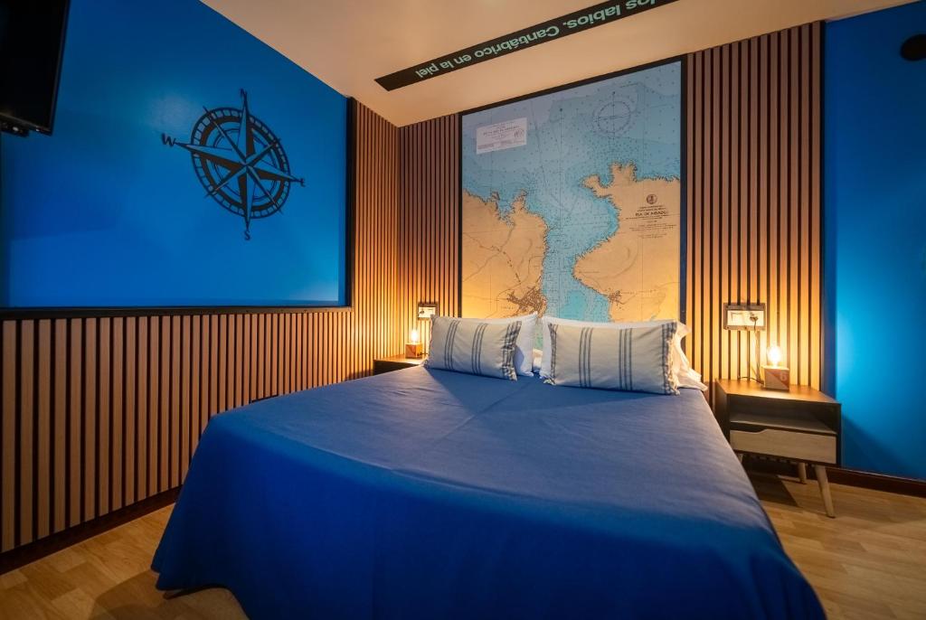a bedroom with a blue bed with a map on the wall at Hotel A. G. Porcillan in Ribadeo