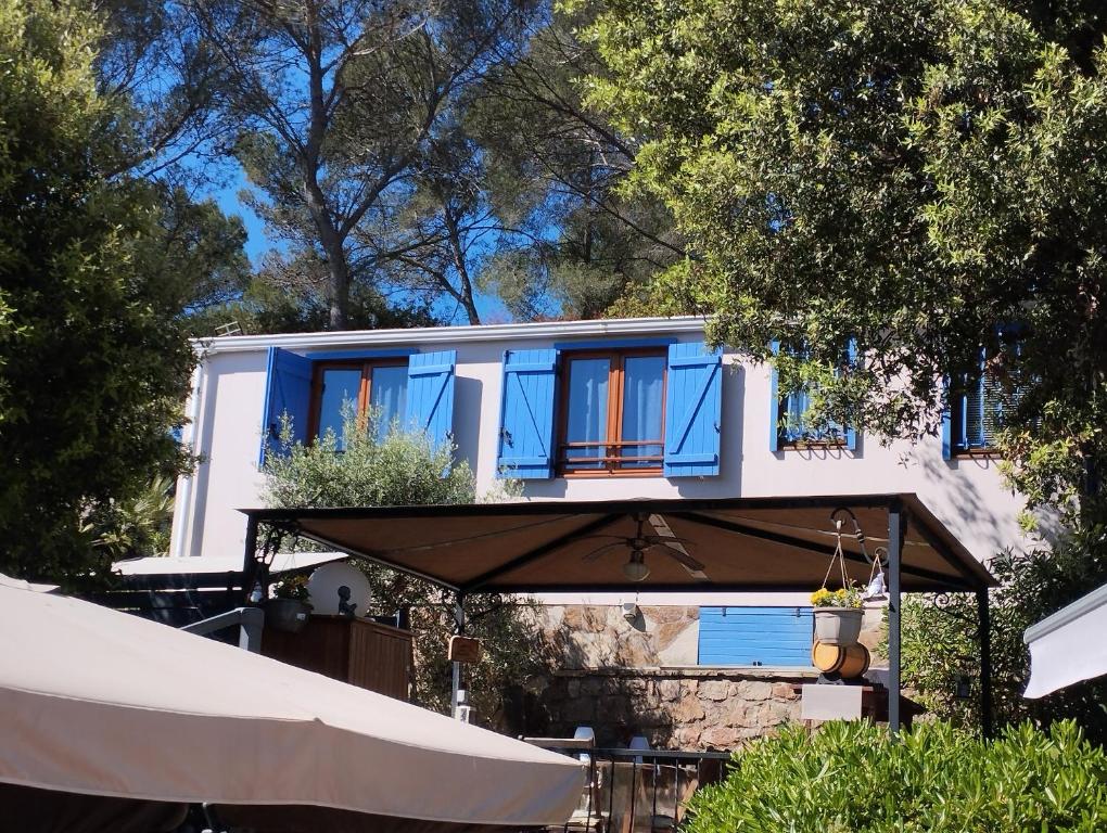 a house with blue windows and an umbrella at Soucado in Fréjus