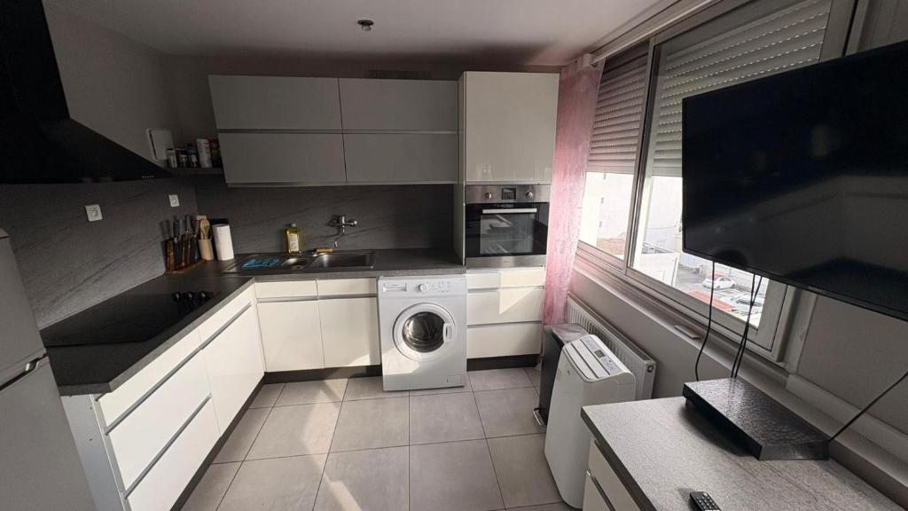 a kitchen with a washer and dryer in it at Appartement 2 Pièces in Annemasse