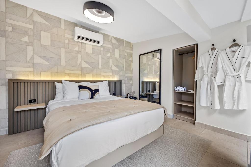 a bedroom with a large white bed and a mirror at The Weekender Hotel in San Juan