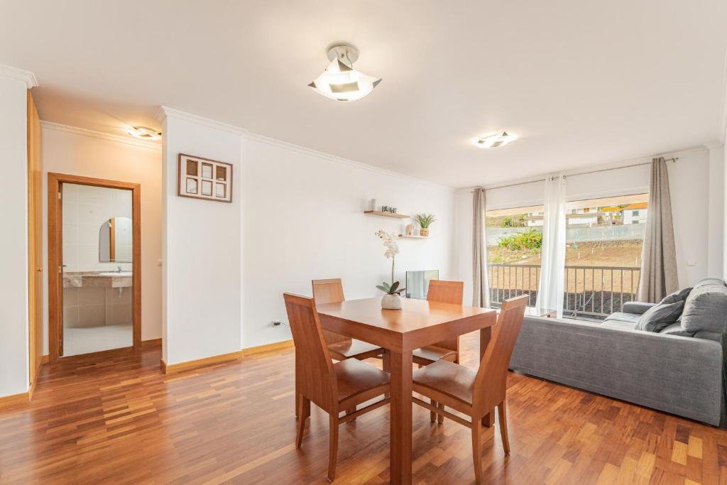 a living room with a table and chairs and a couch at One-Bedroom Apartment near Reis Magos Beach in Caniço