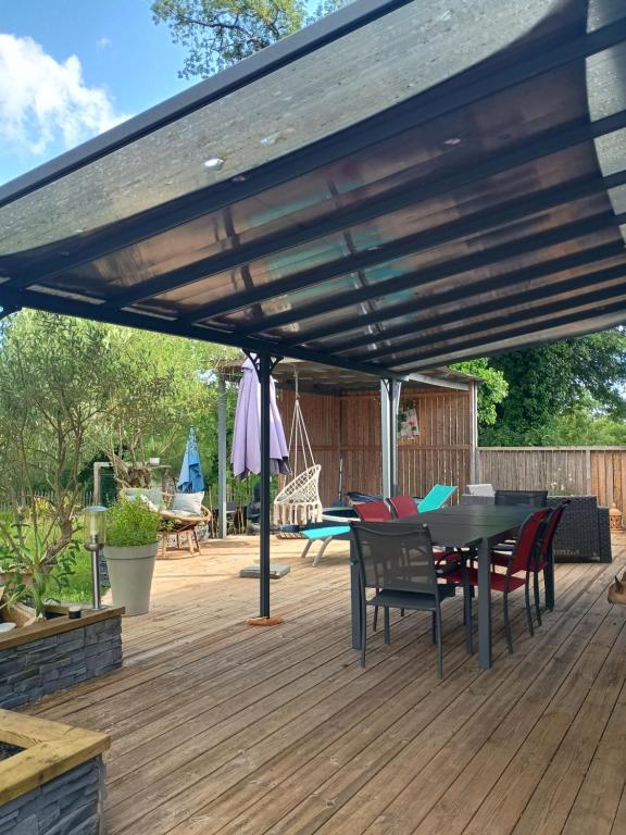 a patio with a wooden deck with a table and chairs at Gite du gachou in Souillac