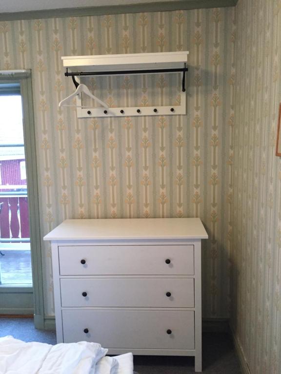 ein Schlafzimmer mit einer weißen Kommode und einer Schublade in der Unterkunft Gästgivars vandrarhem och B&B in Järvsö