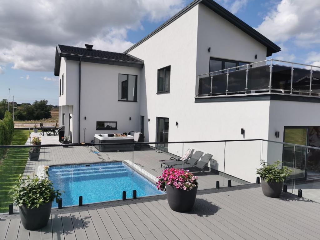 a white house with a swimming pool and a patio at Villa med pool in Bara