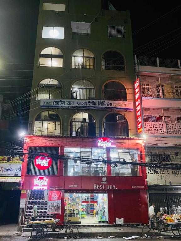 a tall building with a store in front of it at Hotel Al Fahad in Dhaka