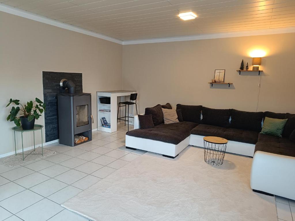 a living room with a couch and a fireplace at Gemütliches Apartment im Naturpark Rhein-Westerwald in Raubach