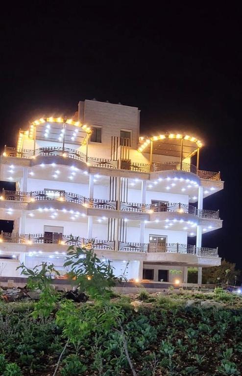 a large building with lights on it at night at Rabab3a Hotel in Ajloun