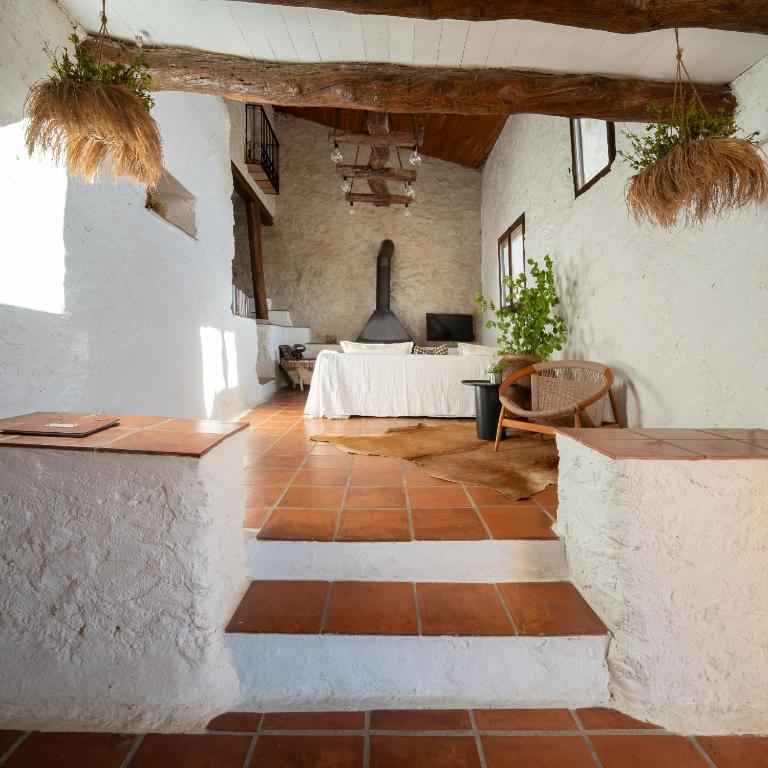 a living room with a bed in the background at Casa Yolanda in Bojar