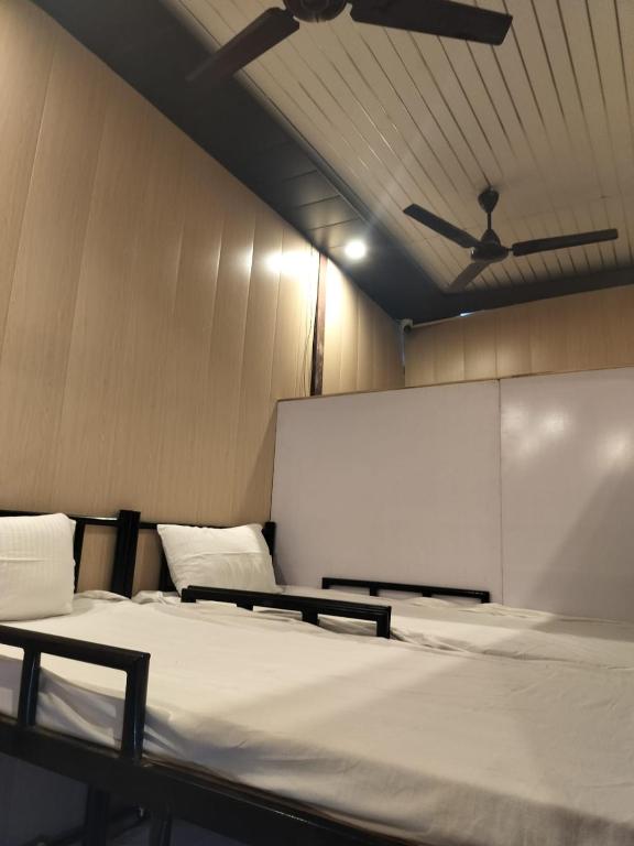 a room with two beds and a whiteboard at AC Dormitory in Varanasi