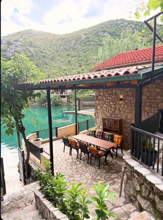 a patio with a table and chairs next to the water at Skadar Lake Hideaway in Karuč