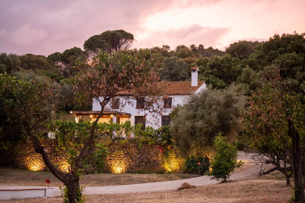 a white house with a stone wall and trees at Finca Santa Teresa, Casa Grande in Estepona