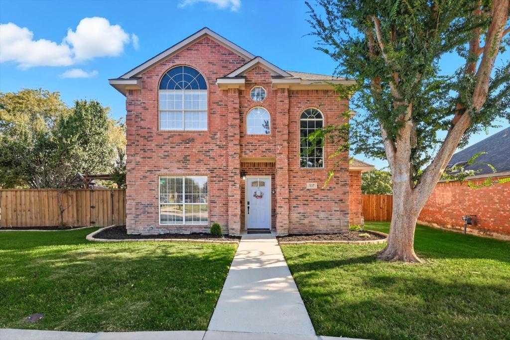 a brick house with a tree in a yard at French-Style 5-BD w/ Pool, Playground, Cinema in Lewisville