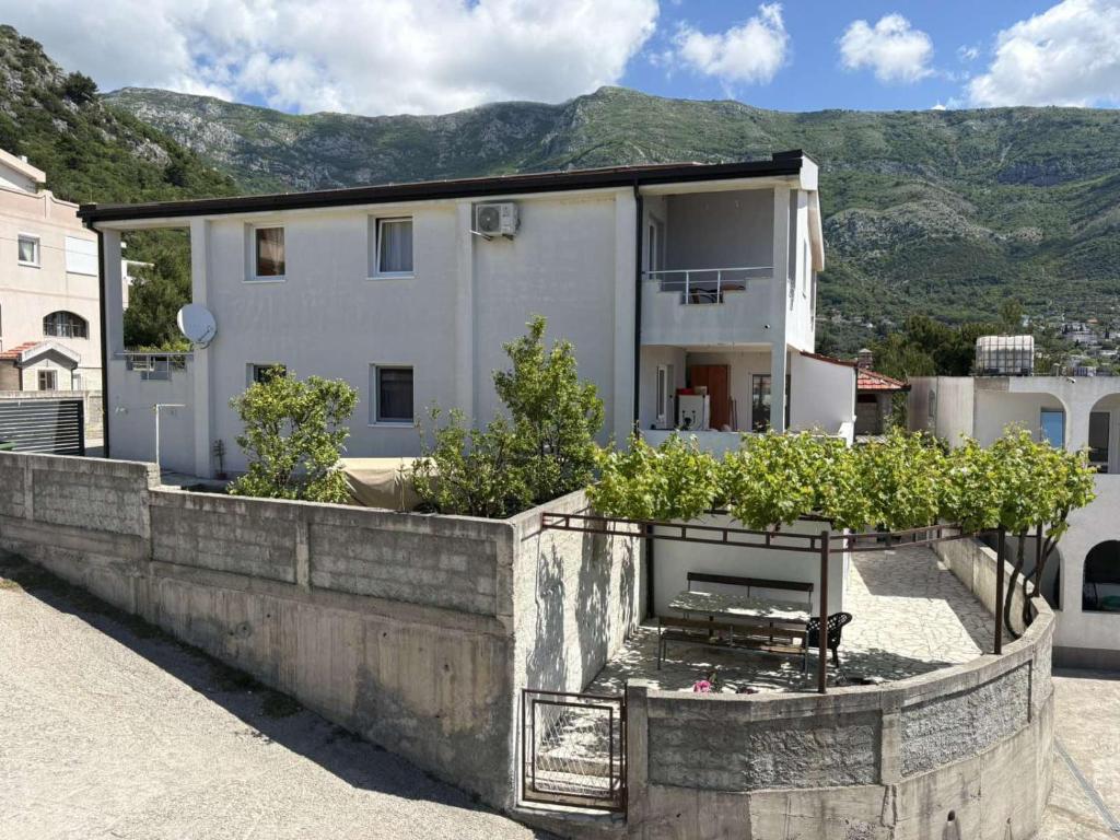 a large white house with some plants in front of it at Apartments Sole1 in Sutomore