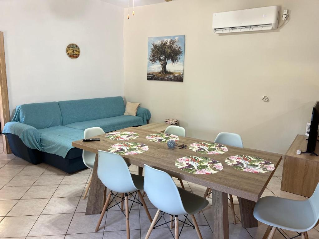 a living room with a table and a blue couch at Casa Koutrea in Kastanéa