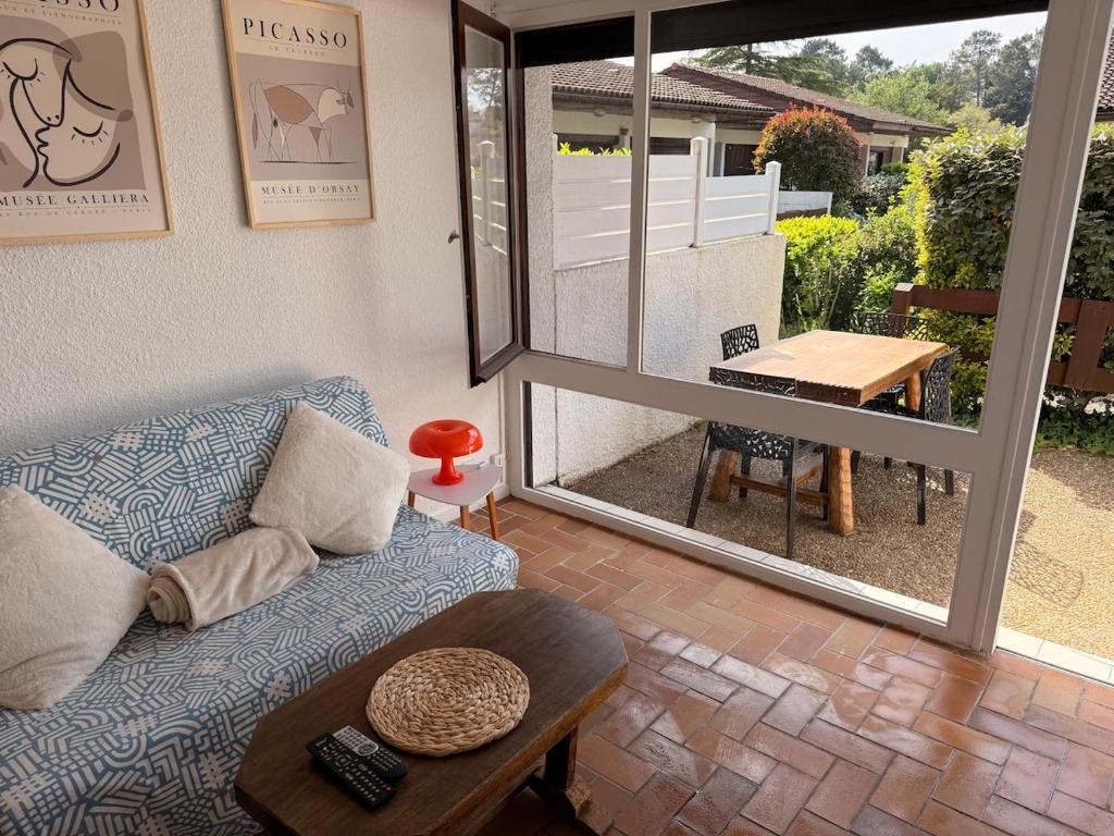 a living room with a couch and a table at Le cottage landais in Lit-et-Mixe
