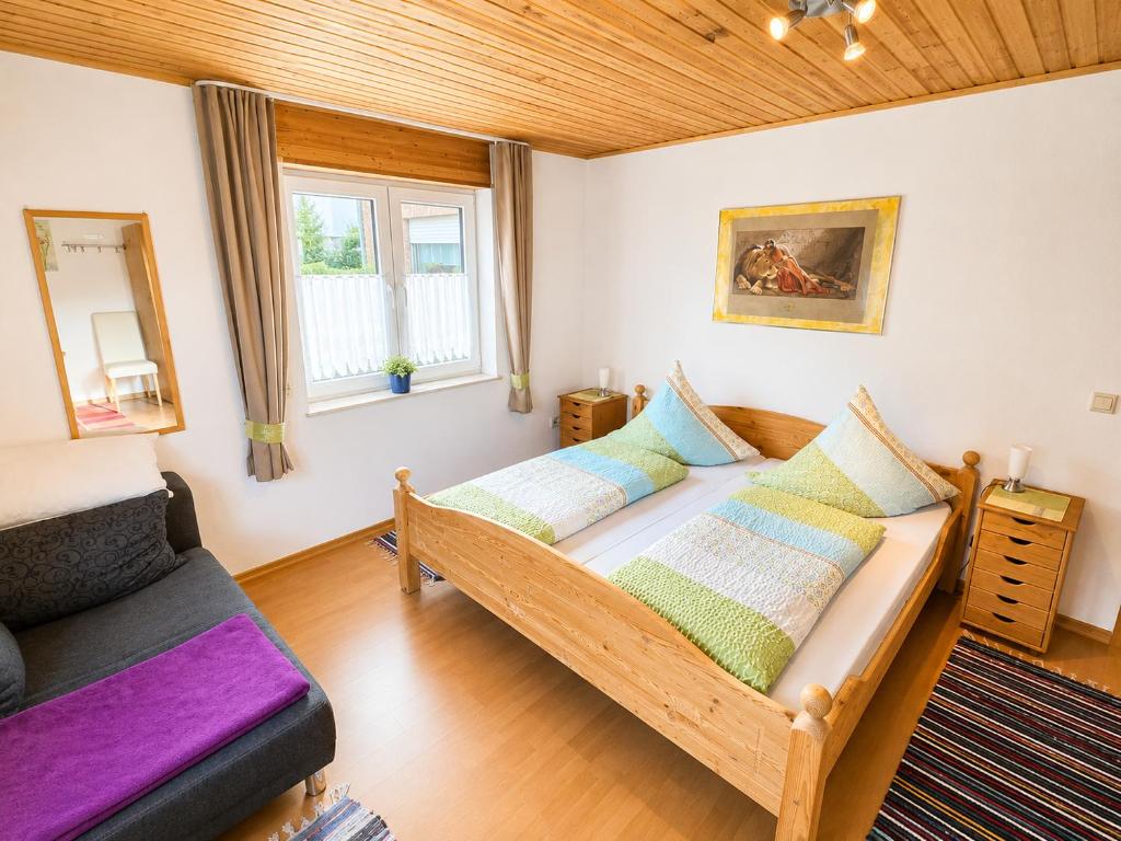 a bedroom with a bed and a couch at Käthe's Gästezimmer in Reimerath