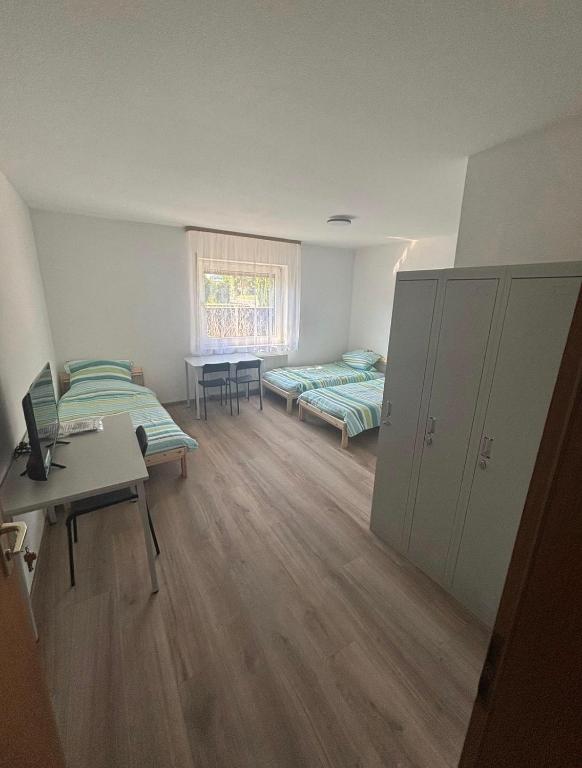 a room with two beds and a table and a window at Monteurhome Monteurzimmer A7 A5 in Niederaula