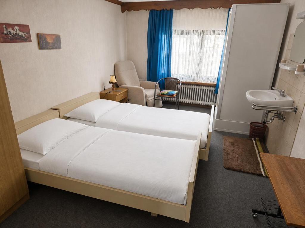 a hotel room with a bed and a sink and a bathroom at GreenHell Stays Monteur - Nürburg in Nürburg