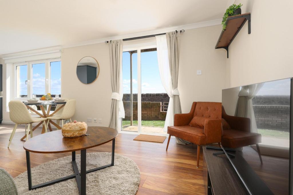 a living room with a table and a chair at Sea Point - 2 bed apartment in Saltcoats