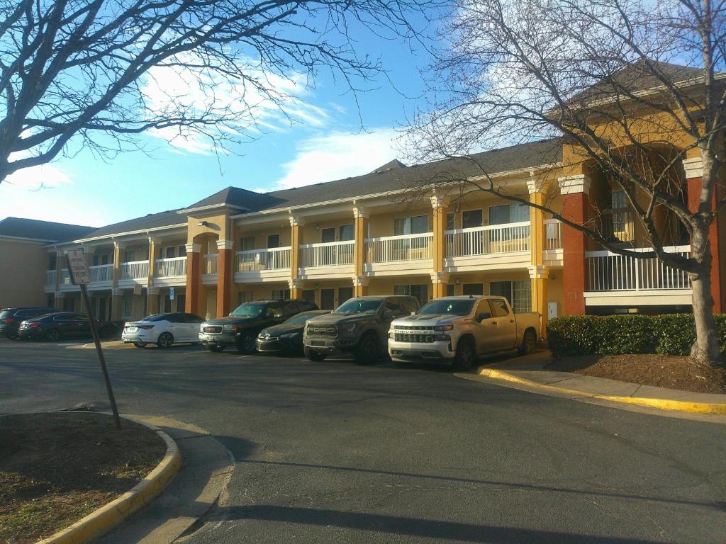 a row of cars parked in front of a building at HomeTowne Studios by Red Roof Chantilly in Chantilly