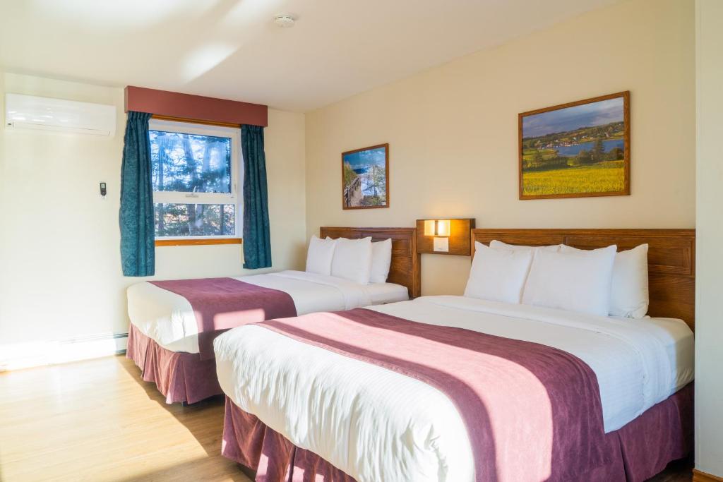 a hotel room with two beds and a window at Dutch Inn in Cornwall