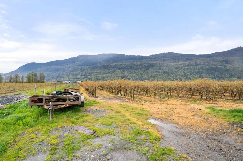 a truck parked in a field with mountains in the background at Private Farm Escape with Modern Comforts in Abbotsford