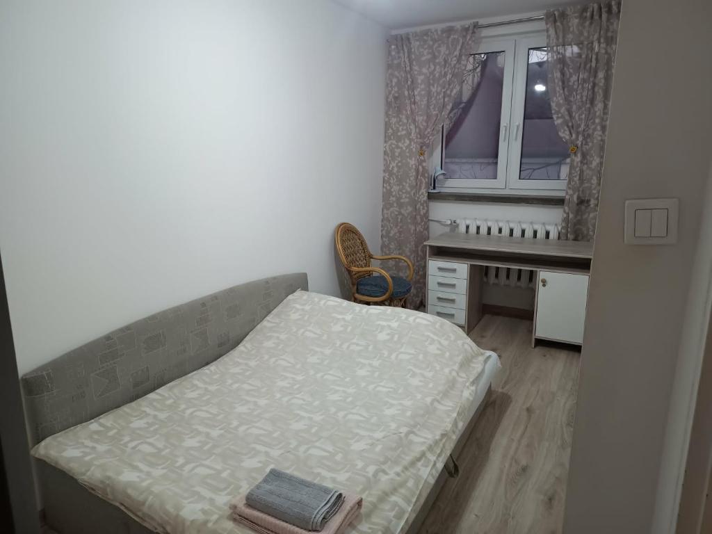 a small bedroom with a bed and a desk at Apartament Kościelna, dwie oddzielne sypialnie in Białystok