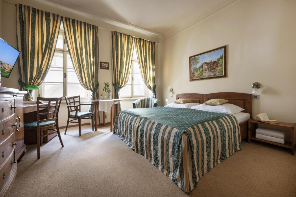 a bedroom with a bed and a table and chairs at U Schnellu in Prague