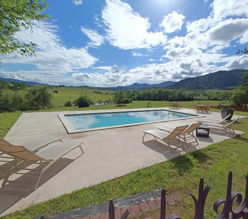 a swimming pool with two chairs and a table at Relais Équestre du Neufeld - Suite ÉTÉ in Oberhaslach