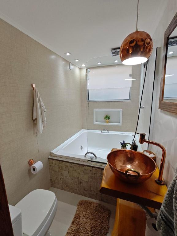 a bathroom with a tub and a bowl sink at Chalé Deruci in Nova Friburgo