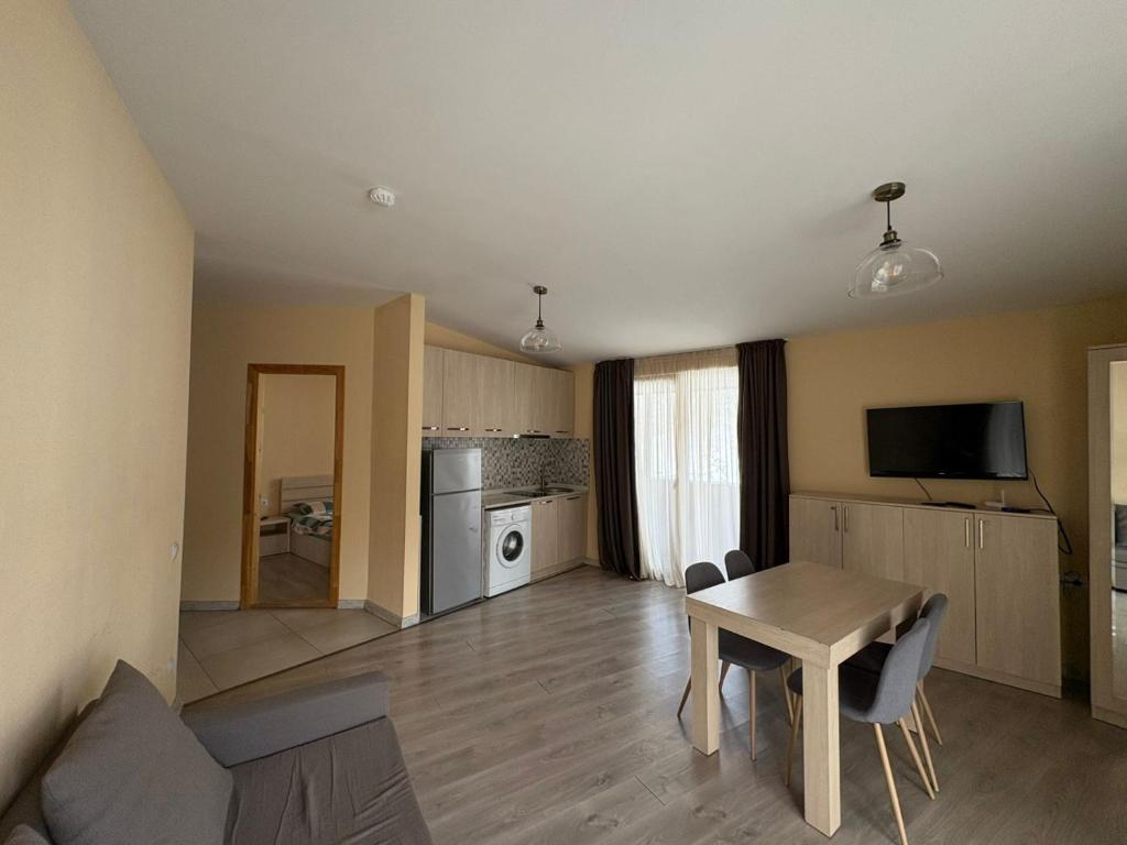 a living room with a table and a kitchen at Bakuriani Valley 10 in Bakuriani