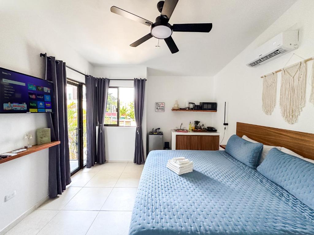 a bedroom with a blue bed and a ceiling fan at TAYGA STUDIOS Cancun in Cancún